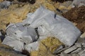 Garbage from white bags and pieces of yellow glass wool