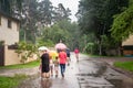 GARCIEMS, LATVIA - AUGUST 26, 2023: Selective blur on a Latvian family, mother, girls, kids and parents, walking under the rain