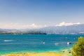 Garda lake with motor boats on blue azure turquoise water, coast with mountain range Royalty Free Stock Photo