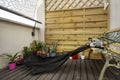 Garden area on an urban terrace with an iron chair, wooden latticework, several plants and an unexpected visitor. Royalty Free Stock Photo