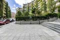 Garden areas with stairs and ramp at the access to an urban residential housing complex with reinforced concrete facades and many