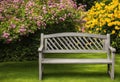 A garden bench surrounded by blooming flowers