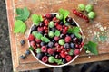 Garden berries in a bowl on wooden table Royalty Free Stock Photo
