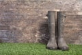 Garden boots on grass against a wooden wall Royalty Free Stock Photo