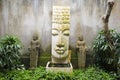 Garden with Buddah style water feature and two small statues of Royalty Free Stock Photo