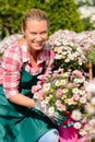 Garden center woman holding potted flowers smiling Royalty Free Stock Photo