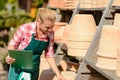 Garden center woman looking down clay pots