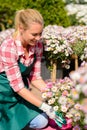 Garden center woman looking down potted flowers Royalty Free Stock Photo