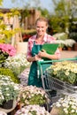 Garden center woman put potted flowers cart Royalty Free Stock Photo