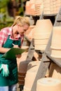 Garden center woman write notes clay pots