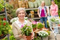 Garden centre senior lady hold potted flower Royalty Free Stock Photo