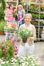 Garden centre senior lady hold potted flower Royalty Free Stock Photo