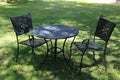 Garden chairs and table on grass.