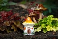 Garden decor of fairy house and mushrooms in a flower bed Royalty Free Stock Photo