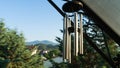 Garden decoration, wind chimes hanging under the roof of the balcony of a house. Cypress tree in the street of a neighborhood in a