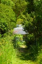 Garden design. Authentic old steel gate entrance to the garden. Countryside authentic cozy little house in a rural area. Garden de Royalty Free Stock Photo