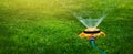 garden equipment - water sprinkler watering lawn at home backyard. banner