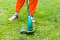 Garden equipment. Young woman mowing the grass with a trimmer.