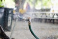 Garden faucet wasting water by cooling the garden faucet wasting water by cooling the yard connected with a green irrigation hose Royalty Free Stock Photo