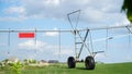 Garden field and irrigation equipment. Wheel line sprinkler irrigates field in fertile farm fields. Irrigation plant for Royalty Free Stock Photo