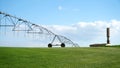 Garden field and irrigation equipment. Wheel line sprinkler irrigates field in fertile farm fields. Irrigation plant for Royalty Free Stock Photo