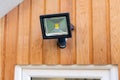 Garden flood sensor light fixed to a wooden wall above a door Royalty Free Stock Photo