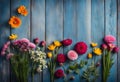 Garden flowers over blue wooden table background. Backdrop with copy space Royalty Free Stock Photo