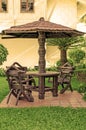 Garden furniture. chairs and table under wooden umbrella at garden