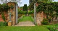 Garden Gate with Plants and Statue. Royalty Free Stock Photo