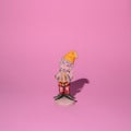 Garden gnome, a small figurine of  elf dwarf, a wise man, with a yellow cat, and red pants on a pink background Royalty Free Stock Photo