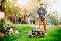 Garden and grass maintenance details - close up view of grass mower and worker Royalty Free Stock Photo