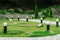 Garden with grass, shrubs and lamps