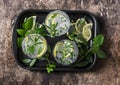 Garden herbs lemonade. Infused water with lemon, rosemary, thyme, sage and mint on wooden background, top view