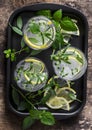 Garden herbs lemonade. Infused water with lemon, rosemary, thyme, sage and mint on wooden background, top view. Royalty Free Stock Photo