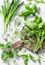 Garden herbs - spinach, basil, thyme, rosemary, sage, mint, onion, garlic on a light background, top view. Fresh food ingredients Royalty Free Stock Photo