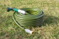 Garden hose green lawn new gardening equipment wrapped up coiled Royalty Free Stock Photo