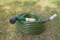 Garden hose green lawn new gardening equipment wrapped up coiled Royalty Free Stock Photo