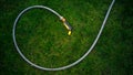 Garden hose lying on green grass at garden Royalty Free Stock Photo