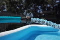 Garden hose pouring water into an inflatable pool Royalty Free Stock Photo