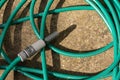 Garden hose with spray nozzle on the ground Royalty Free Stock Photo