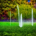 Garden irrigation system lawn. Automatic lawn sprinkler watering green grass. Selective focus. Generative Ai Royalty Free Stock Photo