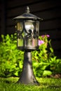 Garden lamp, made in the Middle Ages, on a lawn with a juicy green grass Royalty Free Stock Photo