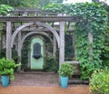 Interesting gardenscape with a fountain and pergola and lots of greenery.