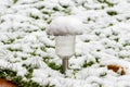 A garden lantern with a light accumulating element is covered with the first snow, close-up. Snowfall and high precipitation in wi