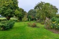 Garden with a Lawn, Flowers and Trees Royalty Free Stock Photo