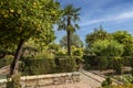Garden with orange and palm trees, cobbled paths for walking. Gardens at the Alcazar de los Reyes Cristianos in Cordoba