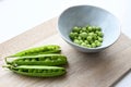 Garden peas (Pisum sativum) in a blue ceramic bowl with three pea pods Royalty Free Stock Photo