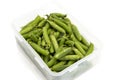 Garden peas in pods freshly picked in a plastic container,  isolated on a white background. Royalty Free Stock Photo