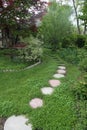 Round Paver Stone Pathway Leading into a Lush Green Garden Royalty Free Stock Photo