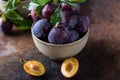 Garden plums on table. Close up of fresh plums with leaves. Autumn harvest of plums. Royalty Free Stock Photo